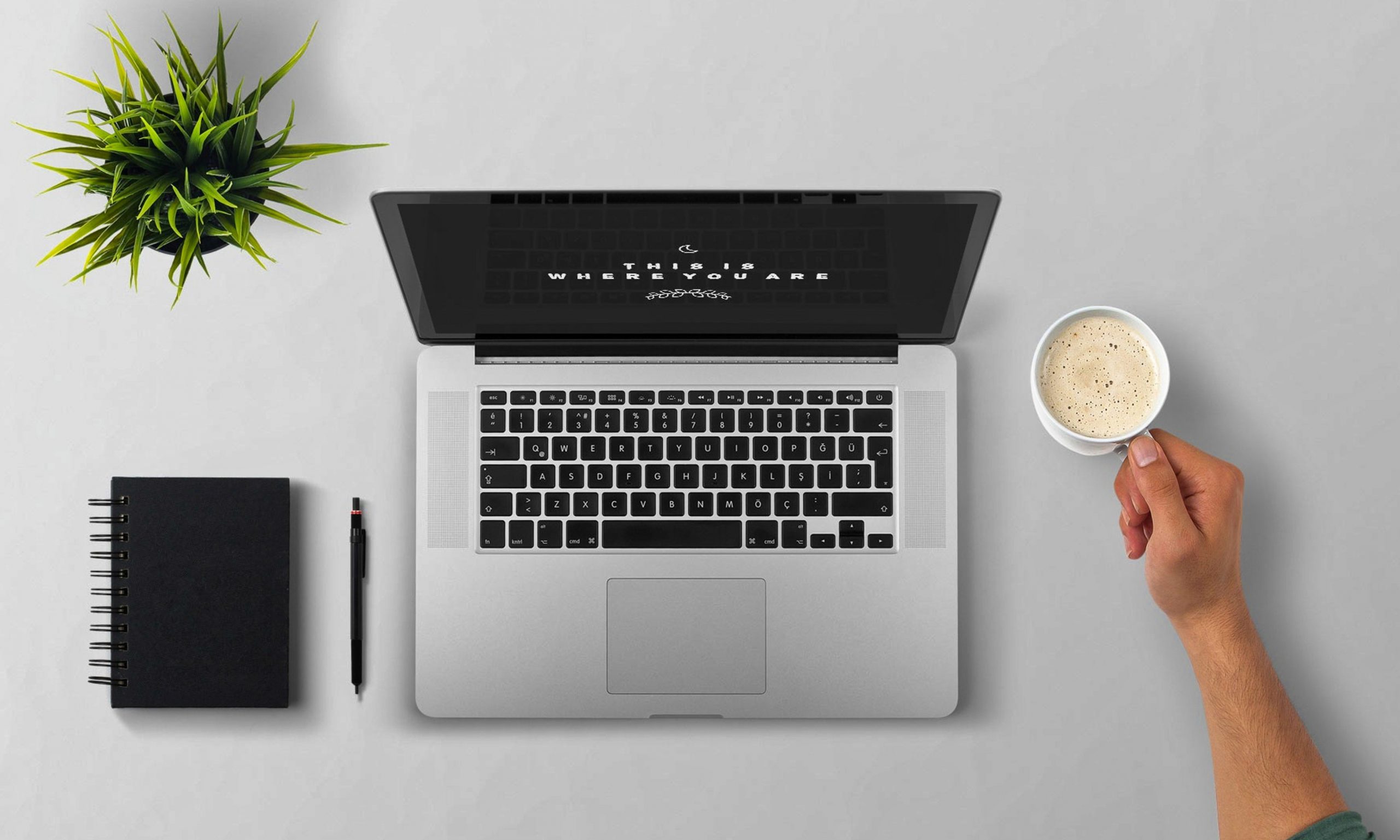 man using mac on white table and coffee